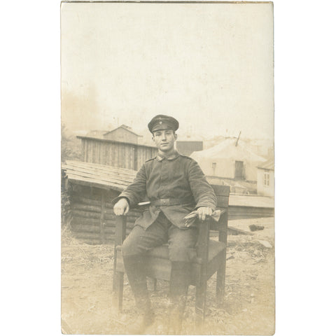 World War I German Soldier Seated Outdoor in Military Camp Photo Postcard